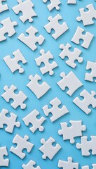 Naklejka premium White puzzle pieces scattered against a bright blue background