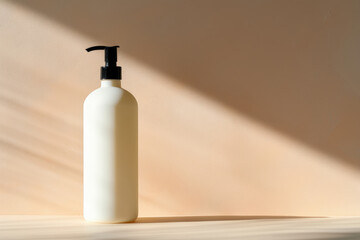 Bottle with dispenser, sprayer, for liquid soap, shampoo, lotion. Mockup concept. Beige background with rays of sunlight, copy space.