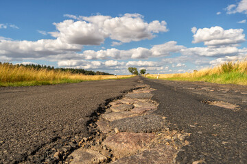 Schlaglöcher in sommerlicher Landstraße