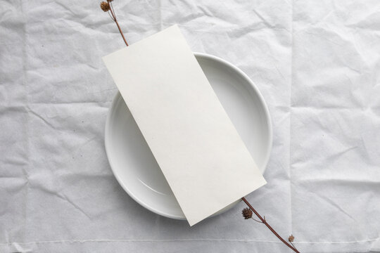 A minimal 5x7 inch blank menu paper placed on a ceramic plate, styled for elegant wedding table settings or fine dining menu mockups.