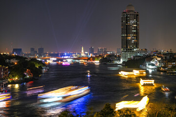 View of Bangkok, Thailand at night, showing the Chao Phraya River and boats. Taken on 22 Dec 2023.