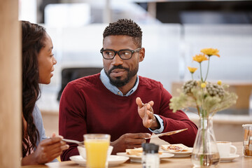 Black couple, discussion and meal on date at cafe for breakfast, healthy food and bonding together. People, talking and restaurant for relationship, romance chat and nutrition snack on valentines day