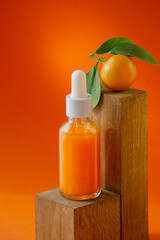 Glass bottle with serum and orange on wooden podium. Unmarked container for cosmetic products with vitamin C. Bright sunny background, mocap concept