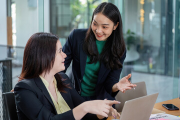 Businesswomen discussing financial planning and strategy at a modern office desk.