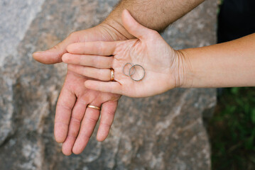 Hands With Wedding Rings On Rustic Rock