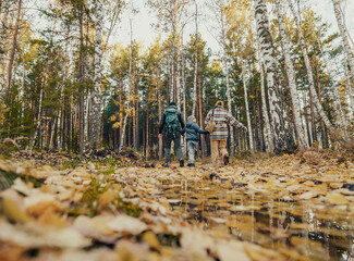 father, mother and son adventure dayhiking in the forest, The adventure nature of the activity creates perfect moments for father-mother-son conversations while developing patience and perseverance.