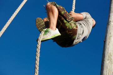 Man, obstacle and climbing on rope outdoor for physical strength, army training and body balance. Below, male person and equipment with strong muscle, core exercise and workout challenge at bootcamp