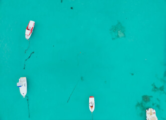 A blue ocean with three boats floating on it