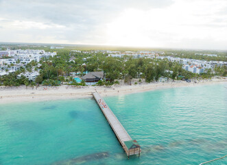 A beautiful beach with a pier and a hotel in the background