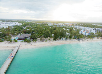A beautiful beach with a pier and a small town in the background