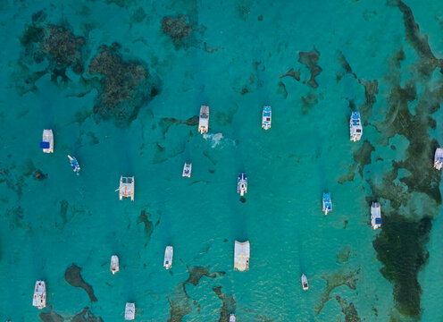A blue ocean with many boats floating on it