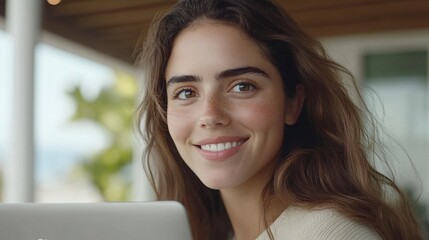 smiling woman working on laptop in natural light