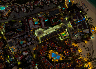 A city at night with many buildings and a pool