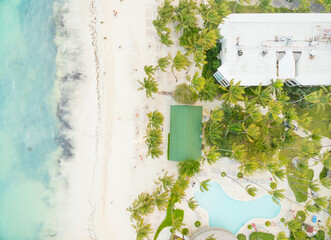 A beach with a green field and a pool