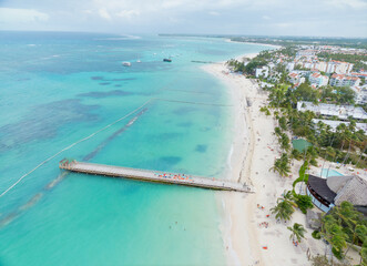 A beautiful beach with a pier and a small town in the background