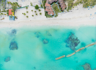 A beautiful blue ocean with a beach and a house in the distance