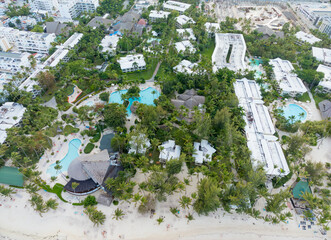 A beach resort with a lot of palm trees and white buildings