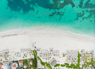 A beach with a lot of umbrellas and a few people