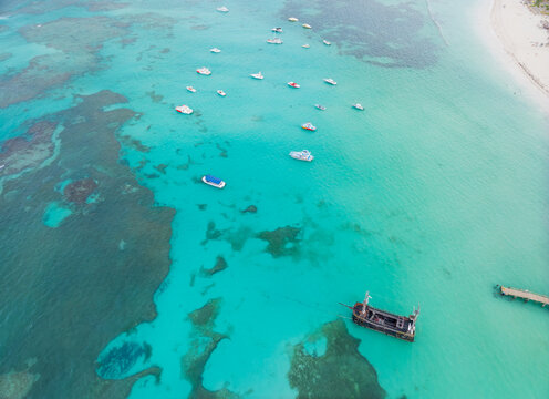 A blue ocean with many boats floating on it
