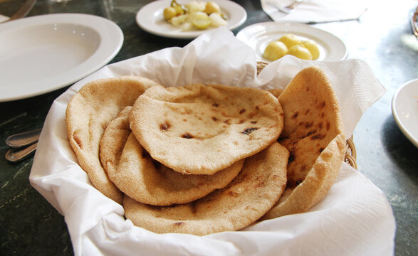 Egyptian flatbread Aish Baladi with side dishes in a Luxor restaurant, Egypt