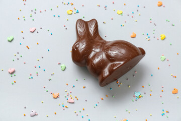 Chocolate Easter bunny and sprinkles on blue background