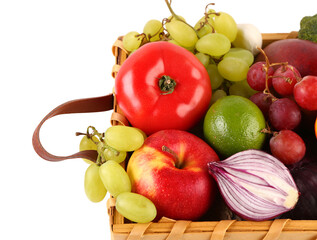 Wicker basket with different fresh fruits and vegetables on white background, closeup