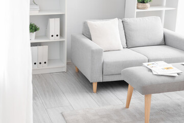 Interior of light living room with soft bench and sofa