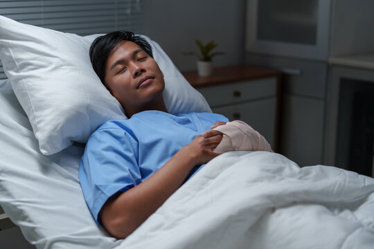 Asian patient sleeping peacefully in hospital bed after surgery