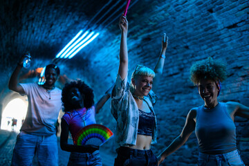 Young people dancing at music festival in a tunnel