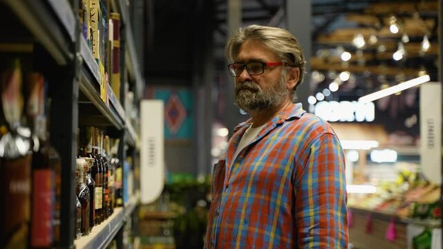 Senior man shopping for luxury alcohol in liquor store
