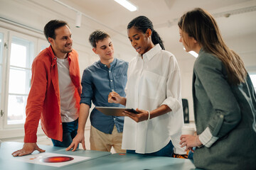 Marketing team discussing new project using tablet and graphic charts during a meeting