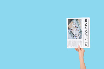 Woman with newspaper on blue background