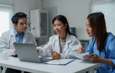 Obraz premium Medical team analyzing data on laptop in hospital meeting
