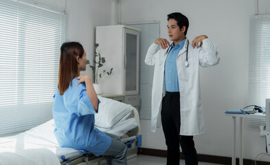 Doctor guiding patient through physical therapy exercises in hospital room
