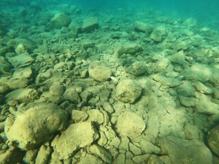 Underwater scene at Kuleli Bay. Under sea view with fishes, sun rays, sen beam, sands and rocks in Fethiye, Mugla, Turkey © emin