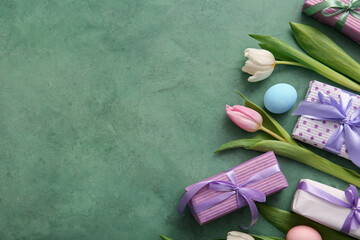 Easter eggs with gift boxes and tulip flowers on green grunge background
