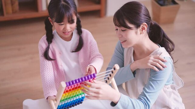 そろばんで遊ぶ園児と保育士