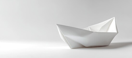 Minimalist white origami paper boat positioned on the right side against a clean white background creating a serene and timeless aesthetic.