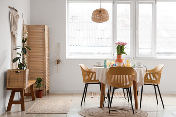 Festive Easter table setting with vase of tulips and bunnies in dining room