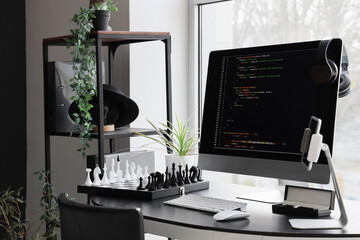 Programmer's desk with computer monitor and chessboard in office
