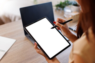Mockup image of business woman sitting on the wooden table using stylus pen and digital tablet with...
