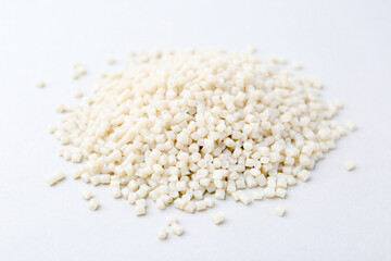 Pile of plastic granules on white background, closeup