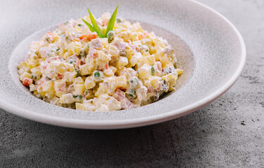 Russian salad with mayonnaise, vegetables and chicken meat being served on the table