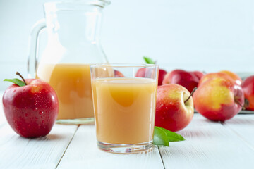 Refreshing apple juice and fruits on white wooden table, closeup