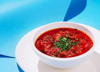 Delicious bowl of borscht soup garnished with fresh herbs