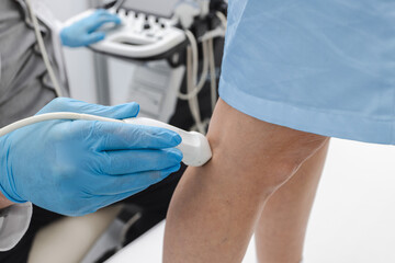 Leg venous ultrasound. Ultrasound vascular diagnostics process of female patient's legs with...