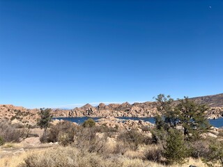 Expansive view of Watson Lake, rock formations & desert vegetation