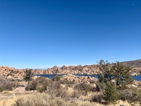 Expansive view of Watson Lake, rock formations & desert vegetation