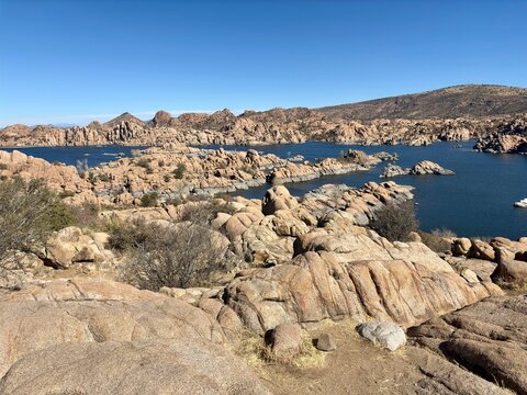 Expansive view of Watson Lake with rugged rock formations, blue sky