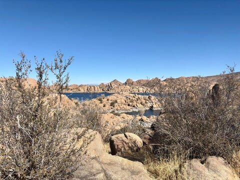 Desert vegetation, rocky terrain overlooking blue lake